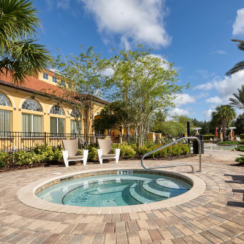 Hot tub at Watersong Resort in Davenport Florida with poolside seating and clubhouse nearby