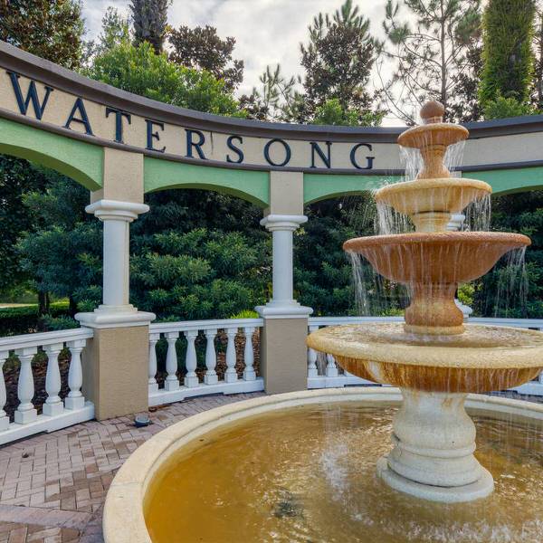 Close-up of Watersong Resort fountain and entrance sign in Davenport Florida with decorative columns and landscaping