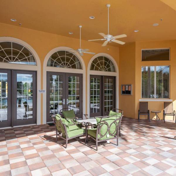 Outdoor seating area at Watersong Resort clubhouse in Davenport Florida with covered patio and fans