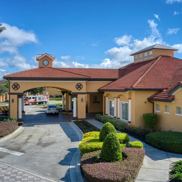 Entrance to Watersong Resort clubhouse in Davenport Florida with covered driveway and landscaping