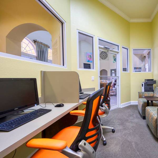 Business center at Watersong Resort Davenport Florida with computers, desks, and lounge seating