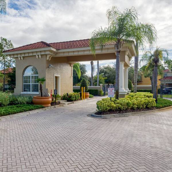 Gated entrance at Watersong Resort in Davenport Florida with security gate and palm-lined driveway