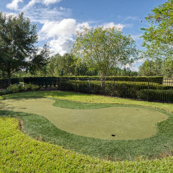 Putting green at Watersong Resort in Davenport Florida with landscaped surroundings and trees