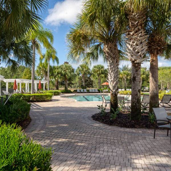 Swimming pool and landscaped grounds at Watersong Resort Davenport Florida with palm trees and seating areas