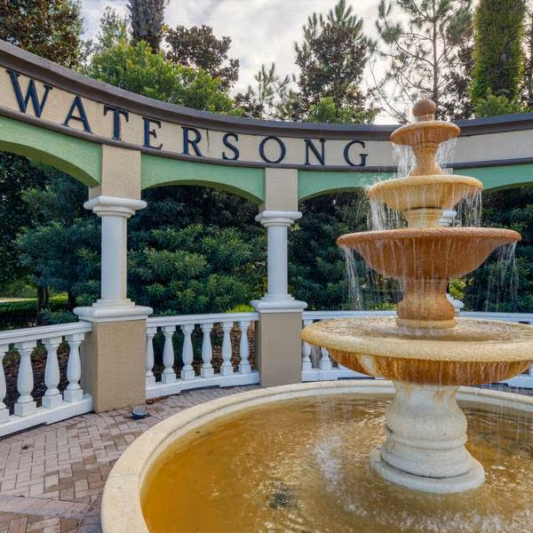 Close-up of Watersong Resort fountain and entrance sign in Davenport Florida with decorative columns and landscaping