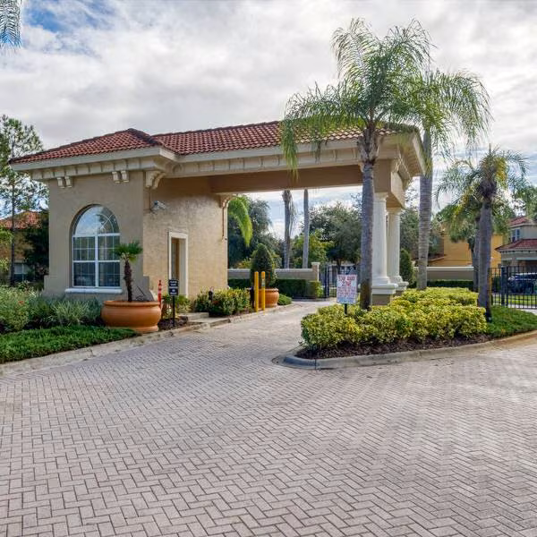 Gated entrance at Watersong Resort in Davenport Florida with security gate and palm-lined driveway