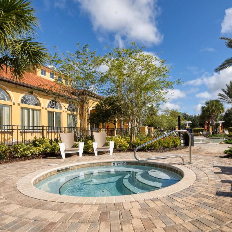 Hot tub at Watersong Resort in Davenport Florida with poolside seating and clubhouse nearby