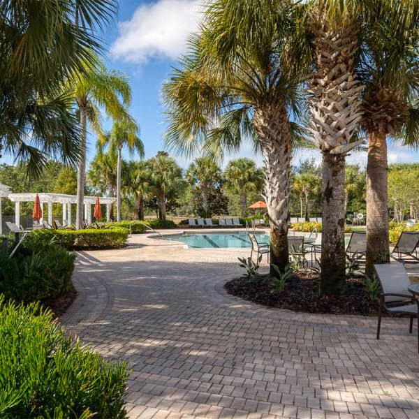 Swimming pool and landscaped grounds at Watersong Resort Davenport Florida with palm trees and seating areas